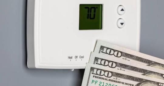 thermostat with money next to it